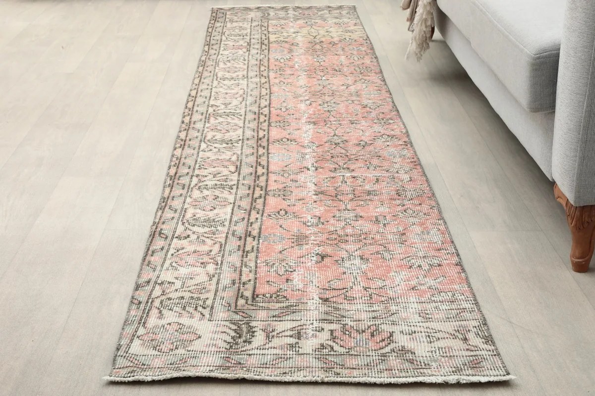 Runner rug from a slightly different angle, highlighting the subtle rose and gray tones on a light floor.