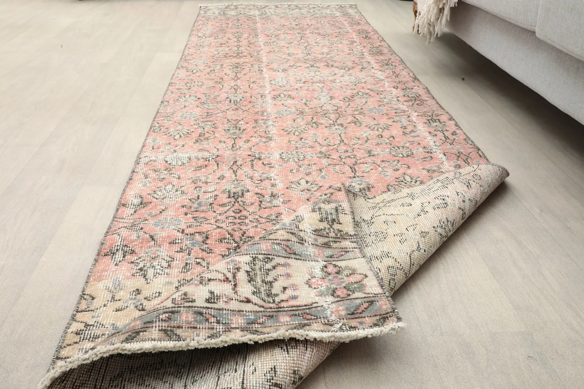 The runner rug partially rolled up, demonstrating its flexibility and thickness