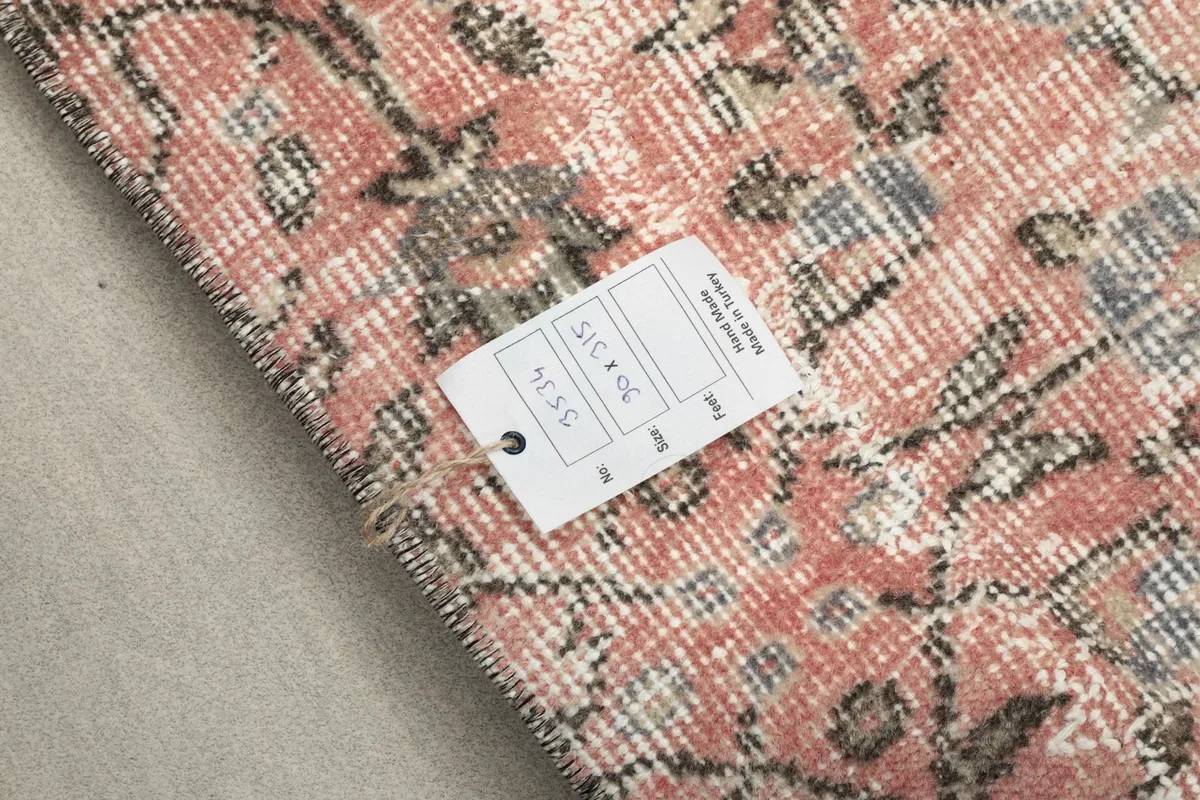 Close-up of the rug's edge with a product tag displaying size and origin information