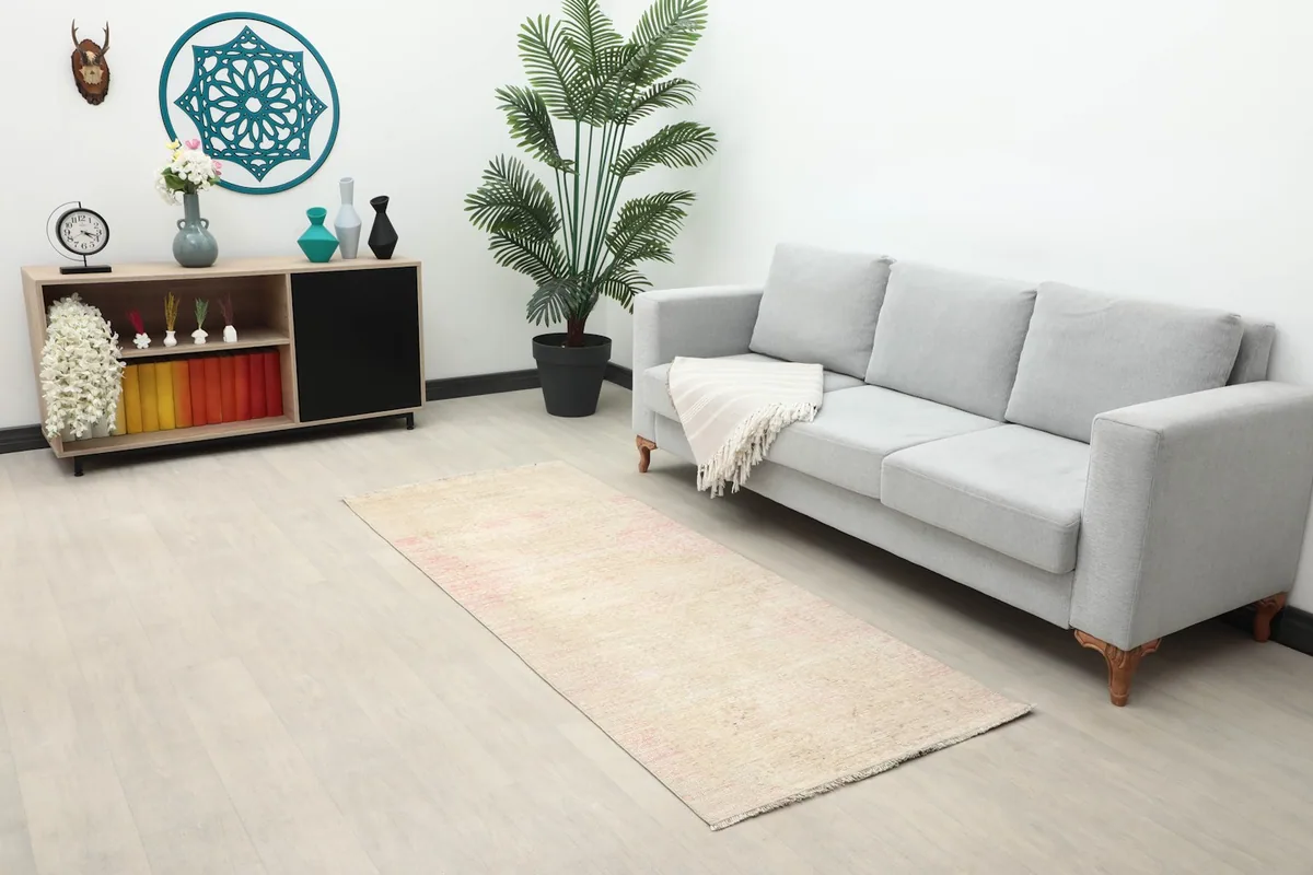 Full room view showing the vintage runner in a living space with a sofa and decor