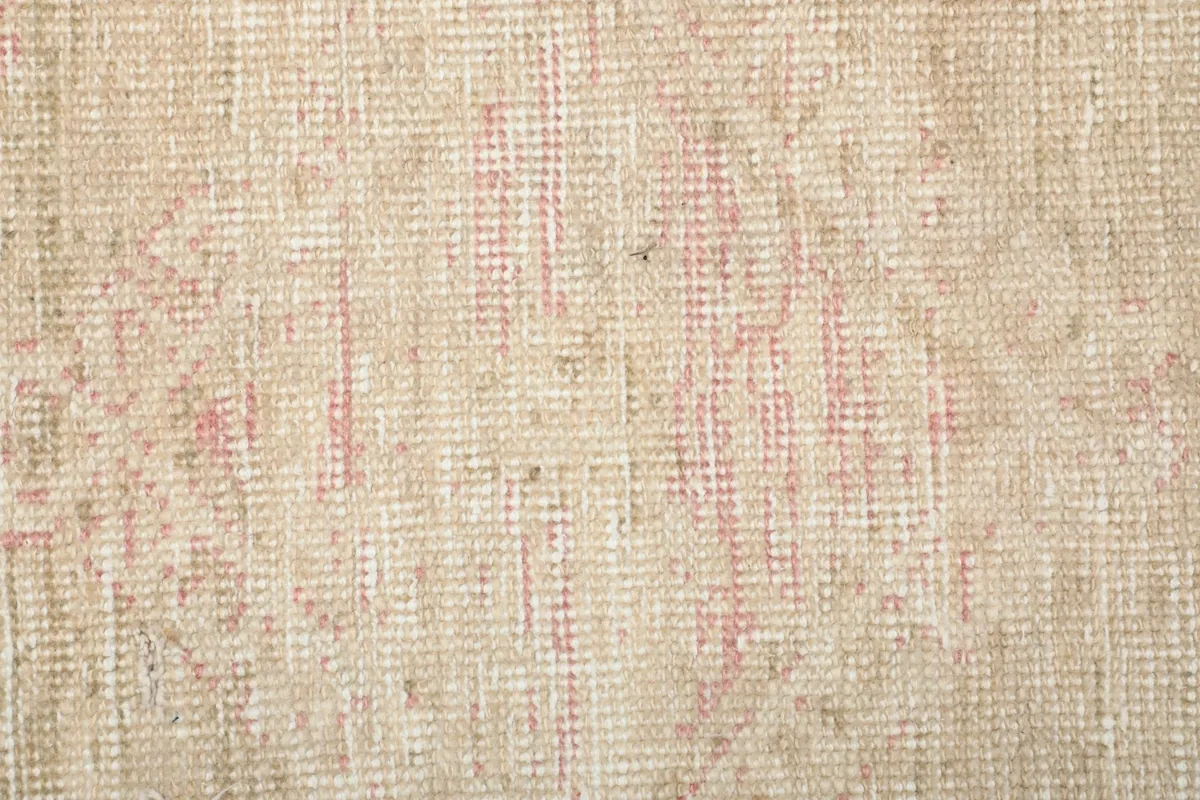 Detailed view of the intricate, faded weaving and color blend in the rug