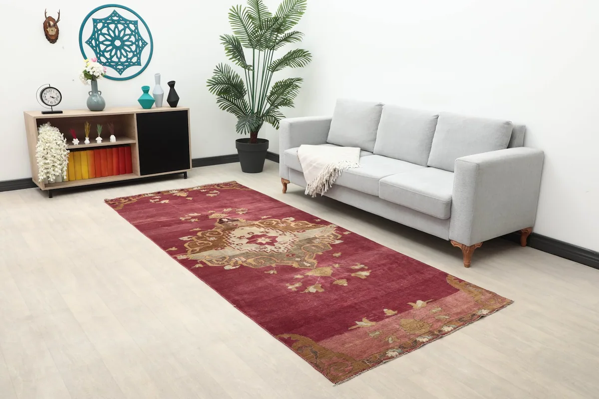 Rose vintage rug laid out in a modern living room setting with a gray sofa.