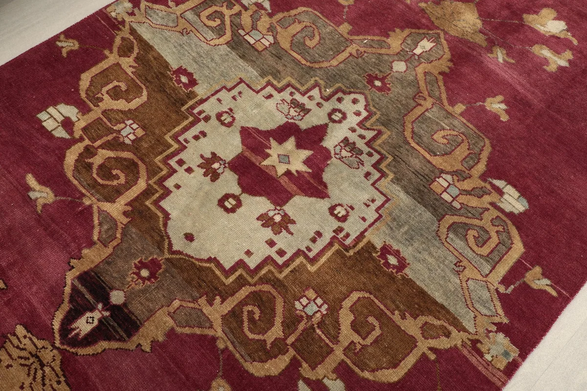 Close-up of the central geometric medallion with beige, brown, and olive tones.