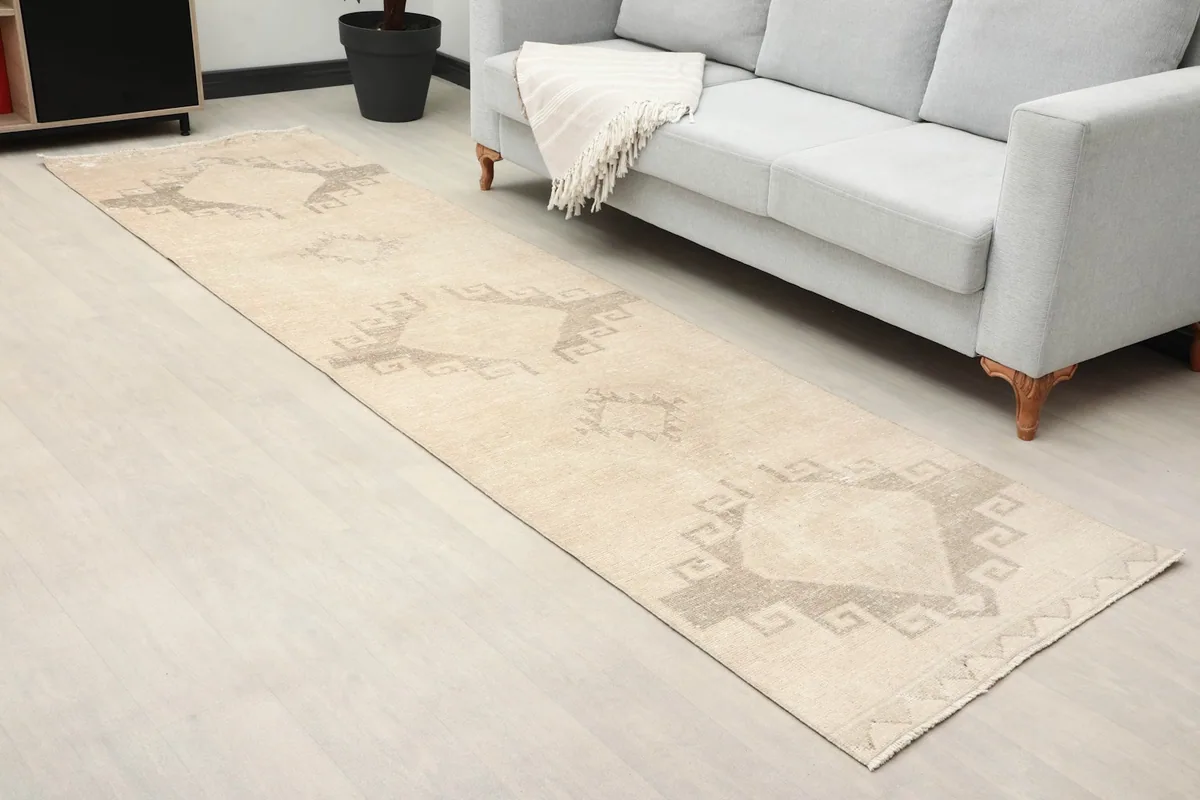 Overhead view of the ivory and gray runner in a room, showing its length and tribal geometric design.