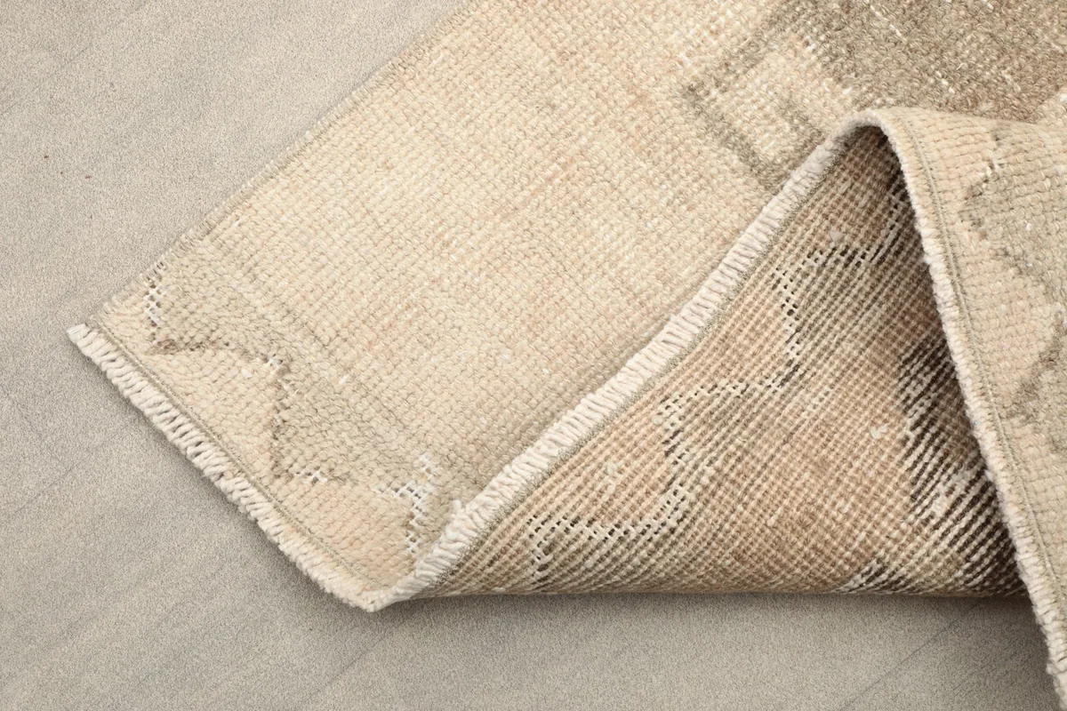 Corner of the runner folded to show the wool pile and the cotton foundation underneath.