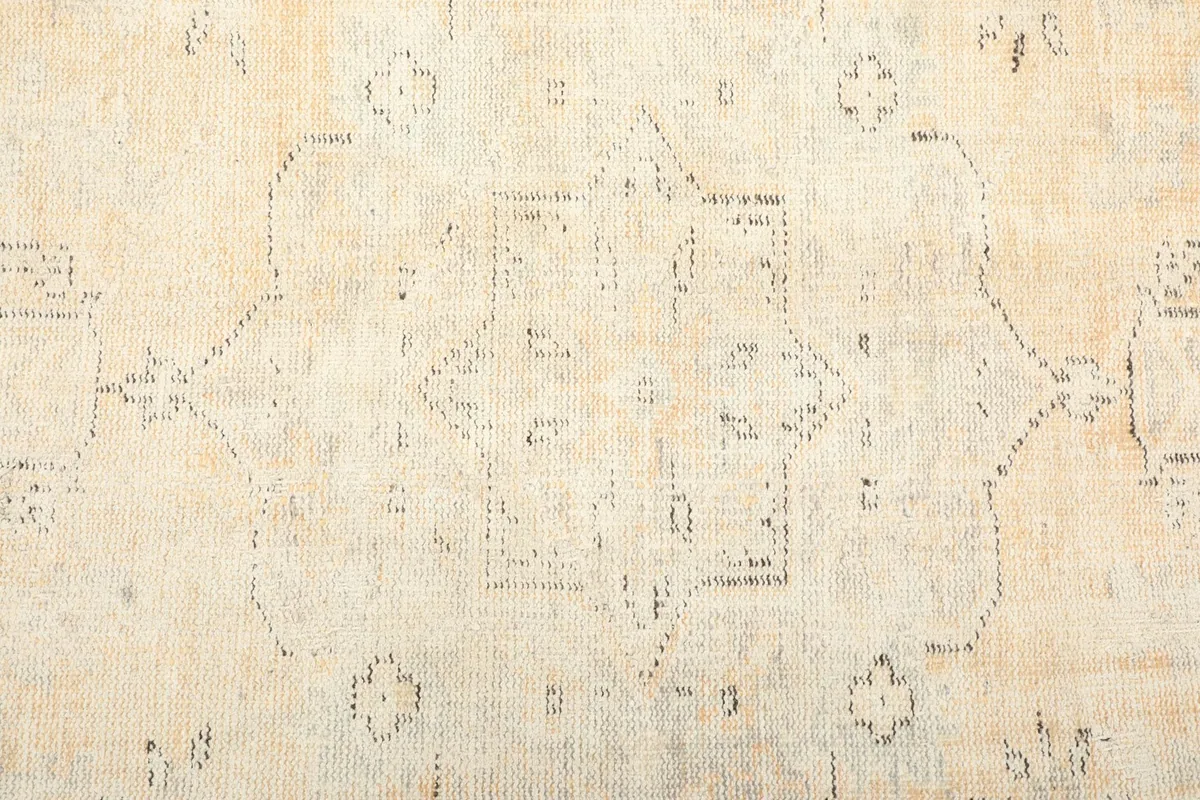 Close-up of the central medallion motif with faded cream and light gray tones