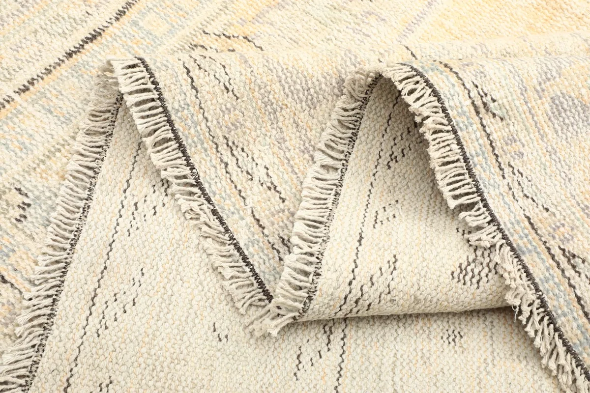 Close-up of the rug's fringe and the texture of the folded wool pile
