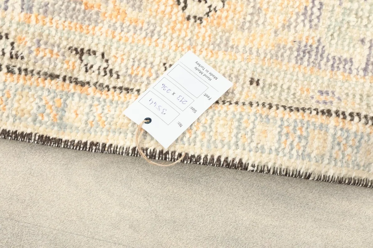 Detail of the rug's edge with a product tag attached, showing the weave and fringe