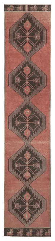 Full overhead view of a vintage rust and charcoal geometric Anatolian runner rug on a white background.
