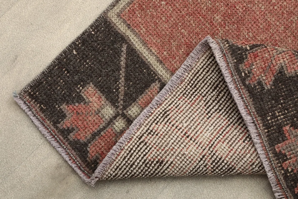 View of the back of the rug, showing the hand-knotted cotton foundation and wool pile.
