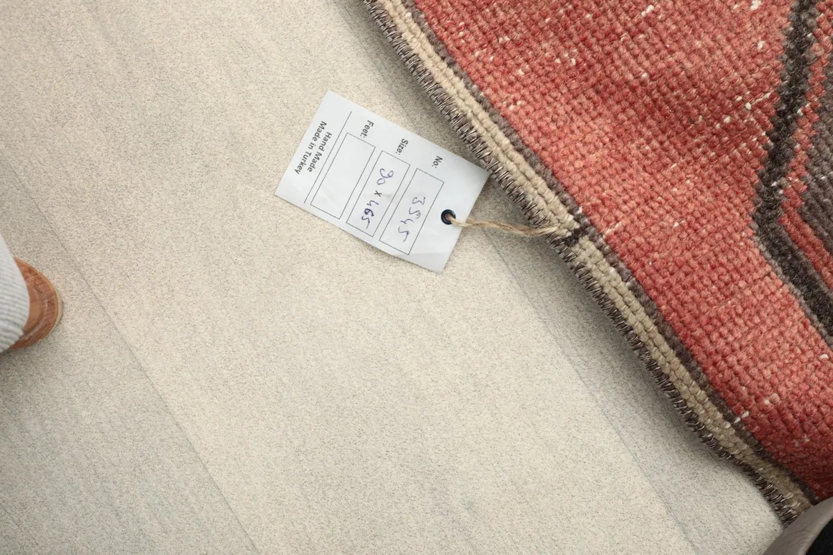 Overhead view of a tag attached to the rug, displaying its size and origin details.