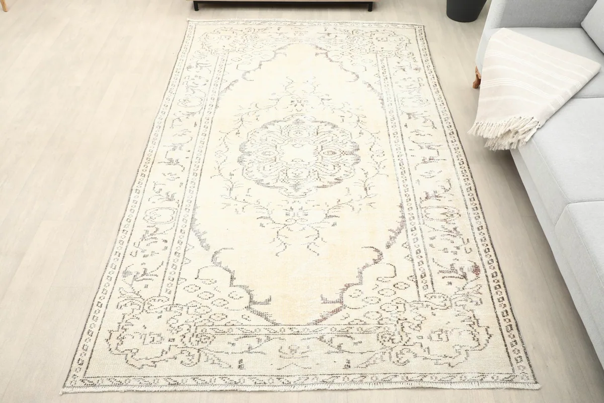 Overhead view of the ivory and gray vintage rug on a light floor, showing its full dimensions