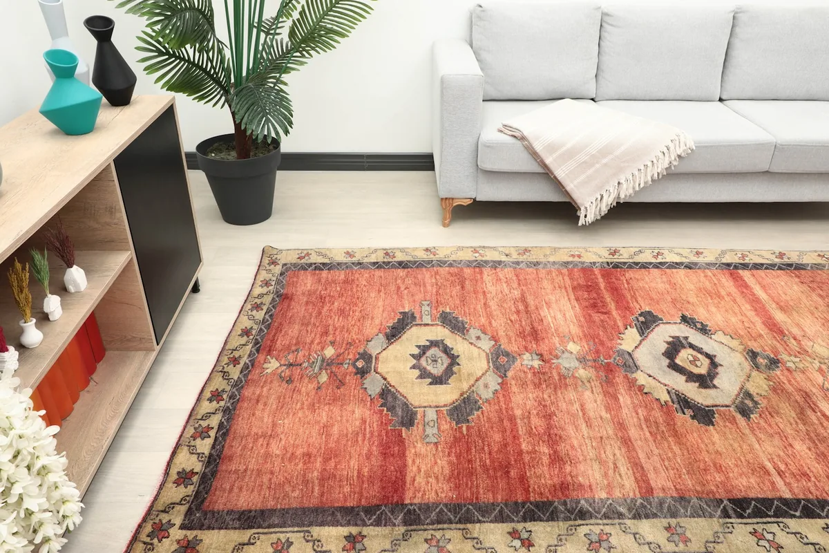 Angled view of the red runner rug in a room, highlighting its length next to a sofa