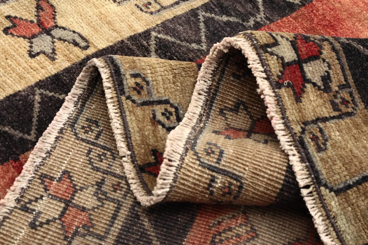 Close-up of the low wool pile and hand-knotted texture of the vintage rug