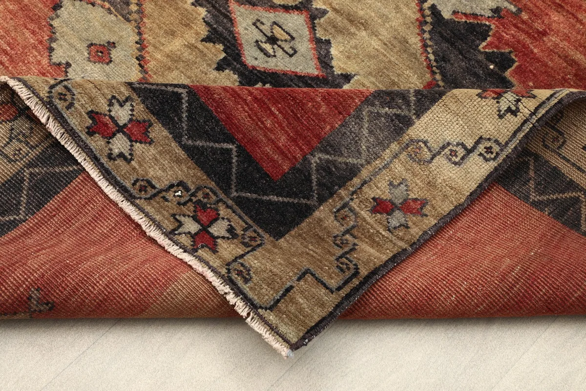 Folded corner of the rug revealing the wool pile and cotton foundation