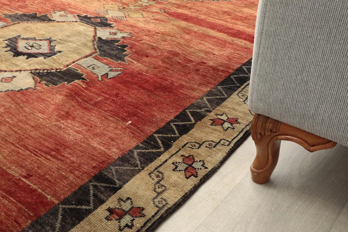 Detail of the rug's border and a sofa leg, showing the rug's placement in a room