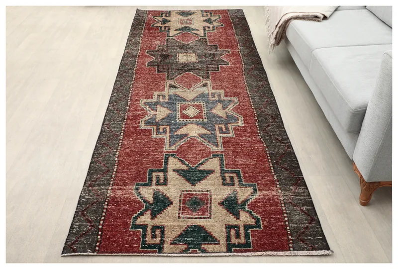 Top view of a 3'7" x 10'0" vintage Anatolian runner rug with rust, gray, beige, and blue geometric patterns.