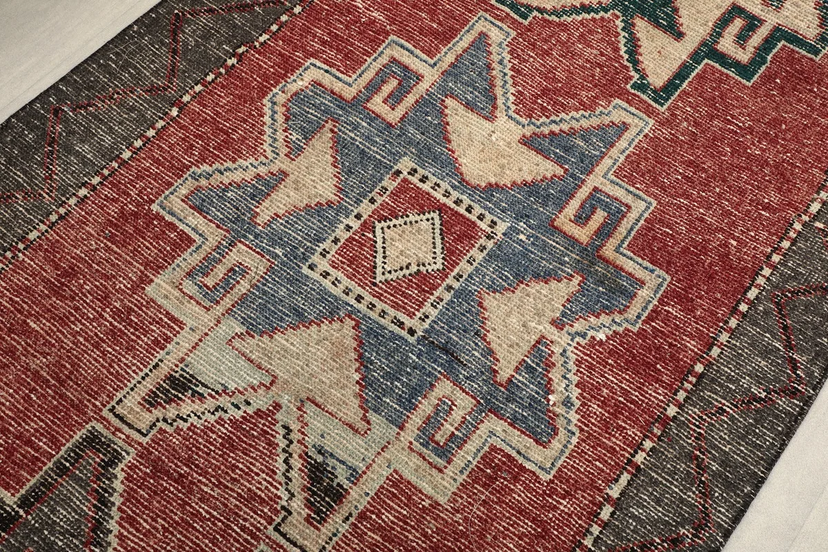 Angled close-up showing the intricate geometric design and color variations in the rug's center.
