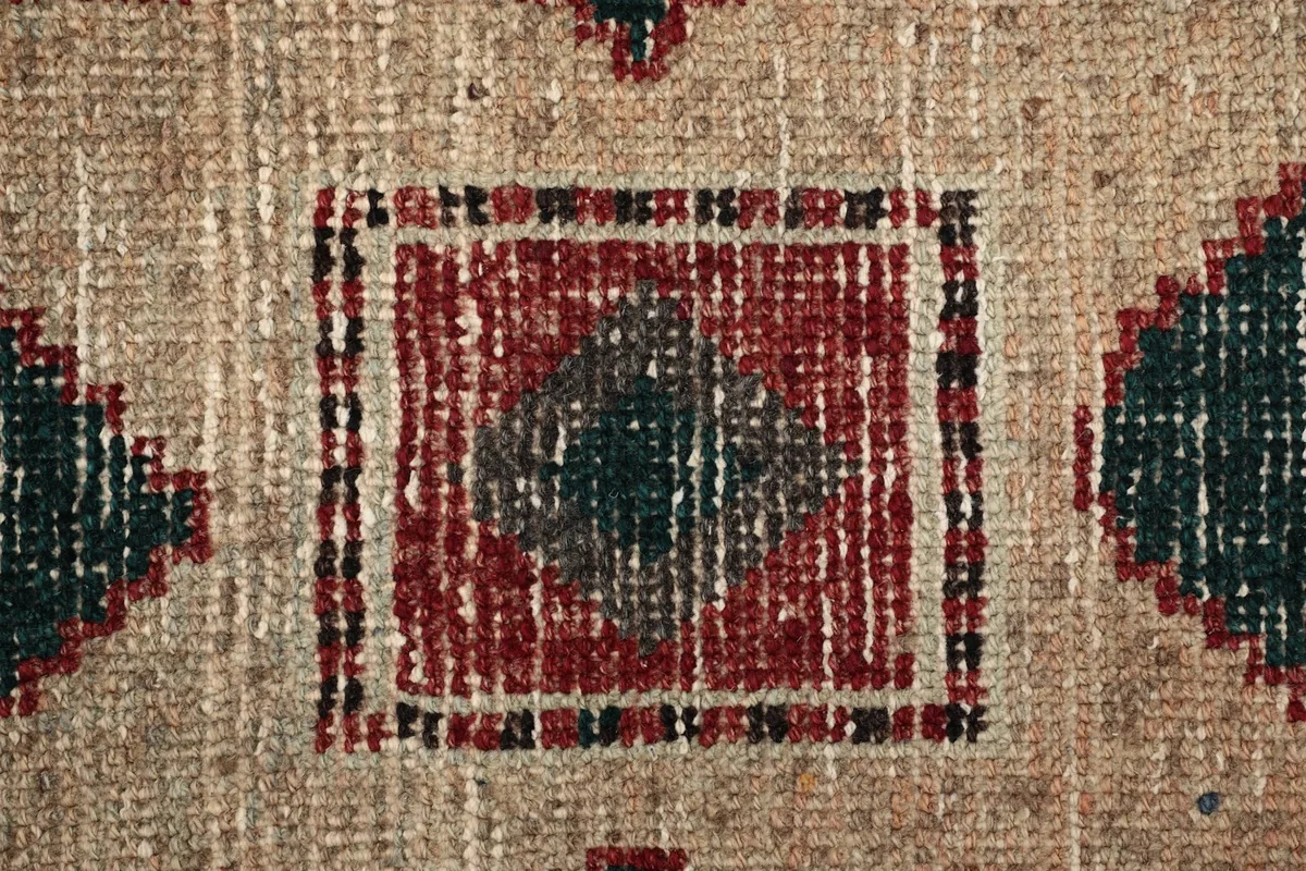 Macro shot of the hand-knotted wool pile, revealing the texture and subtle color shifts.