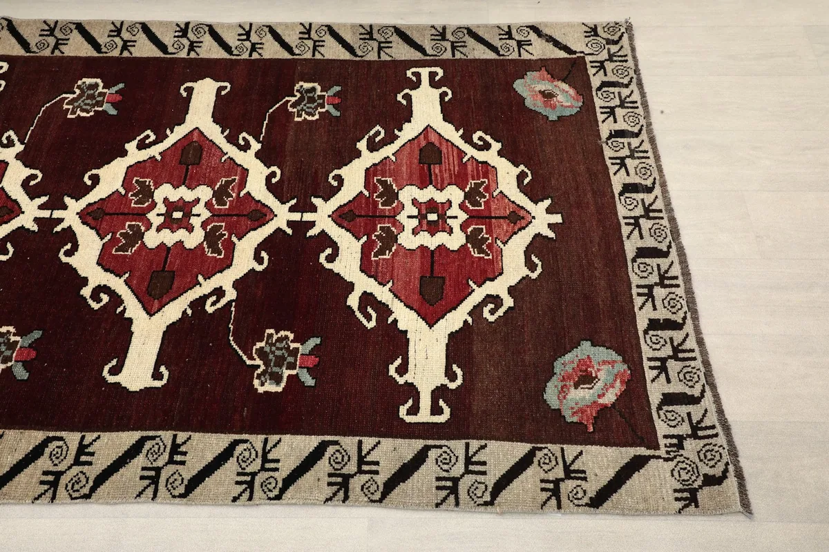 Close-up detail of the red and ivory geometric motifs and beige border patterns
