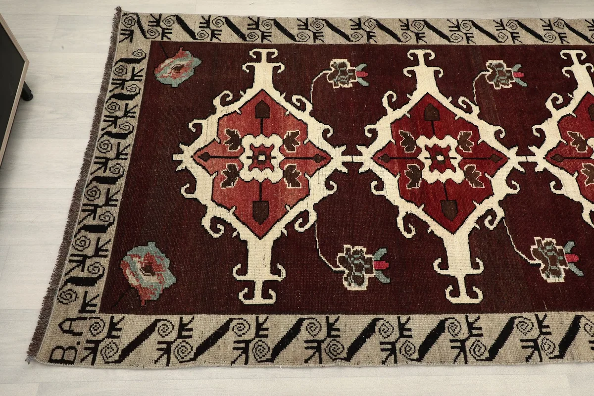 Detail view of the rug's tribal patterns and border design from an angle