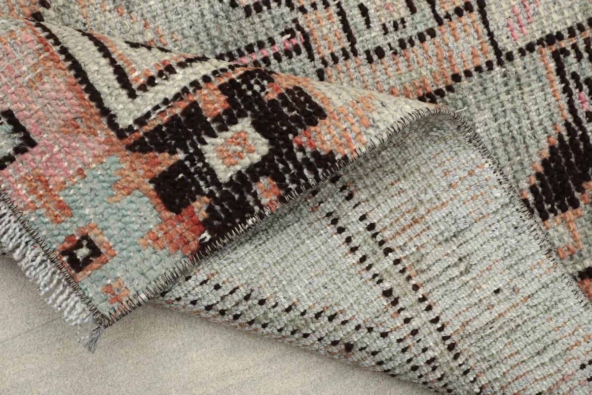 Underside of the rug, showing the cotton foundation and the reverse of the hand-knotted wool pile.