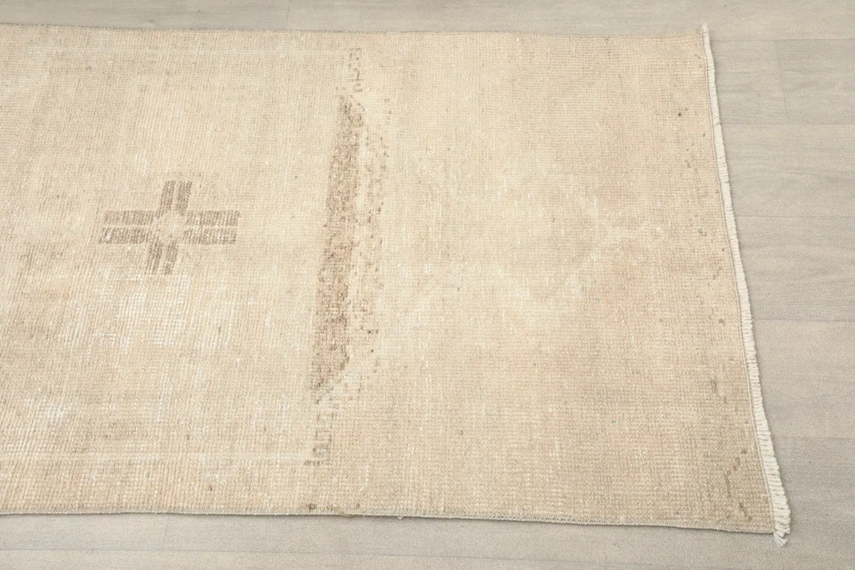 Close-up angle view of the ivory runner, highlighting a tan geometric motif and subtle wear
