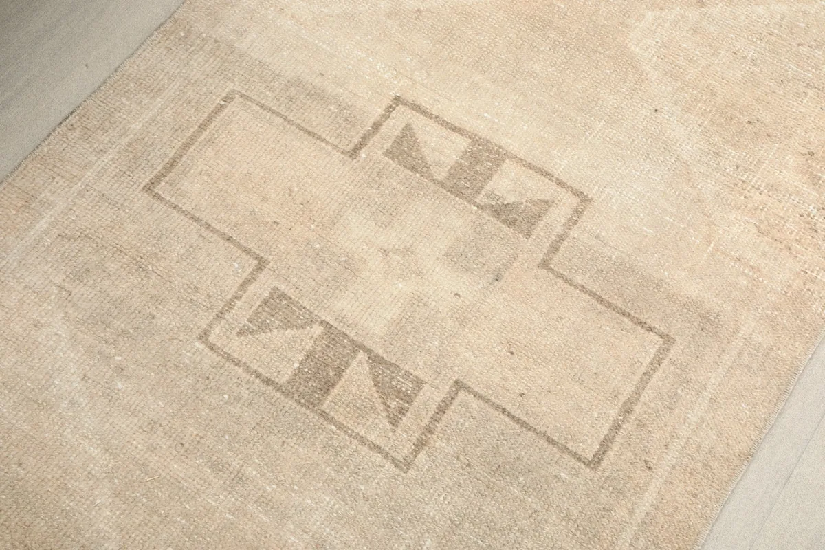 Detailed view of the central tan geometric motif on the ivory field of the runner