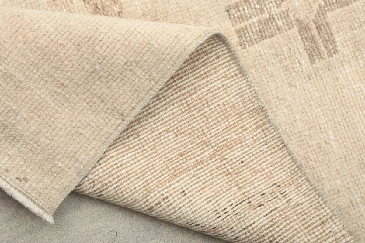 Underside of the runner rug, revealing the tightly woven cotton foundation and knotting