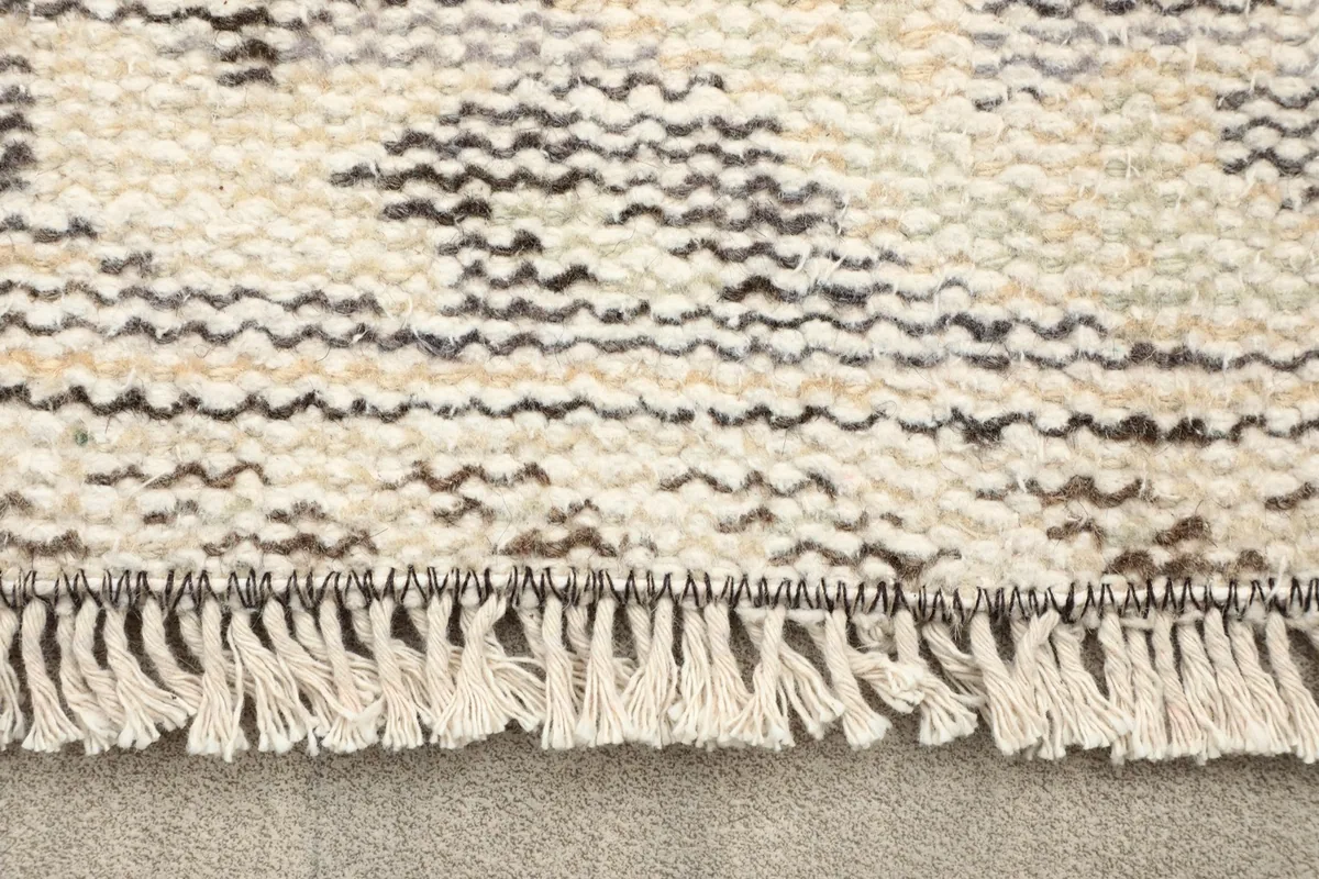 Close-up of the short fringes and the textured back of the hand-knotted wool rug