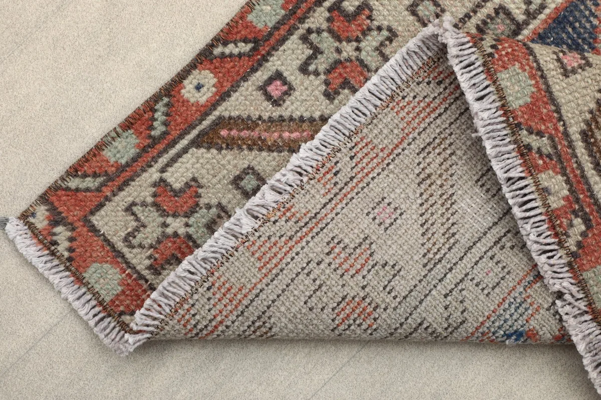 Corner folded back to show the hand-knotted cotton foundation and fringe of the runner rug.