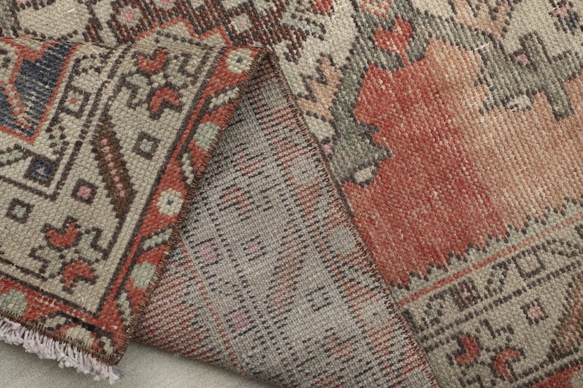 View of the rug's back, revealing the intricate hand-knotting and weave of the vintage piece.