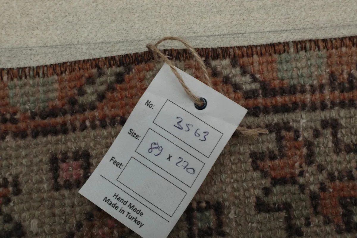 Product tag displaying the rug's unique number, size in feet and centimeters, and 'Hand Made in Turkey'.