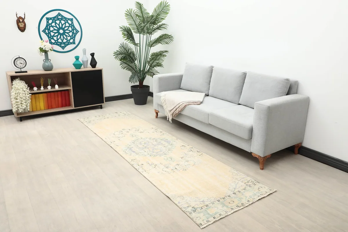 Overall view of the cream and blue runner rug placed in a living space with modern furniture.