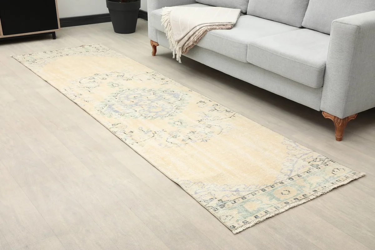 Angle view of the runner rug extending from the sofa, highlighting its length.