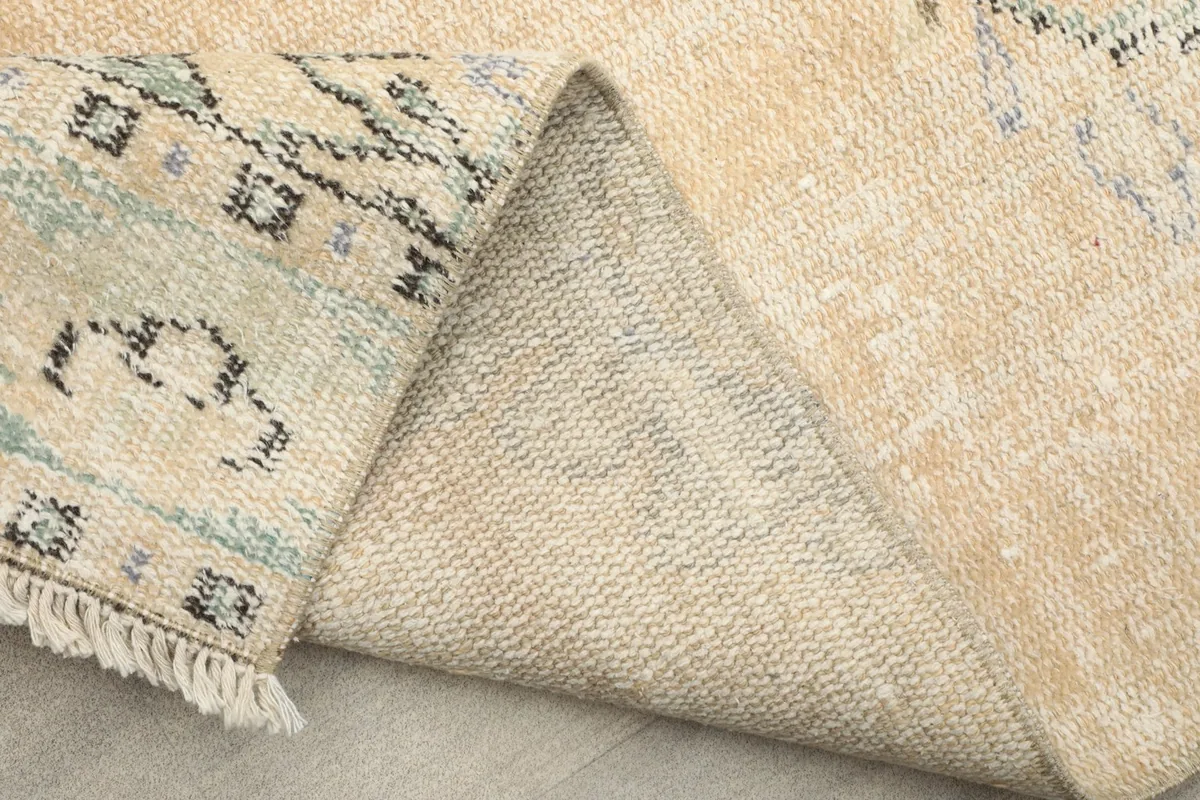Close-up of the back of the rug where it is folded, showing the tight knotting.