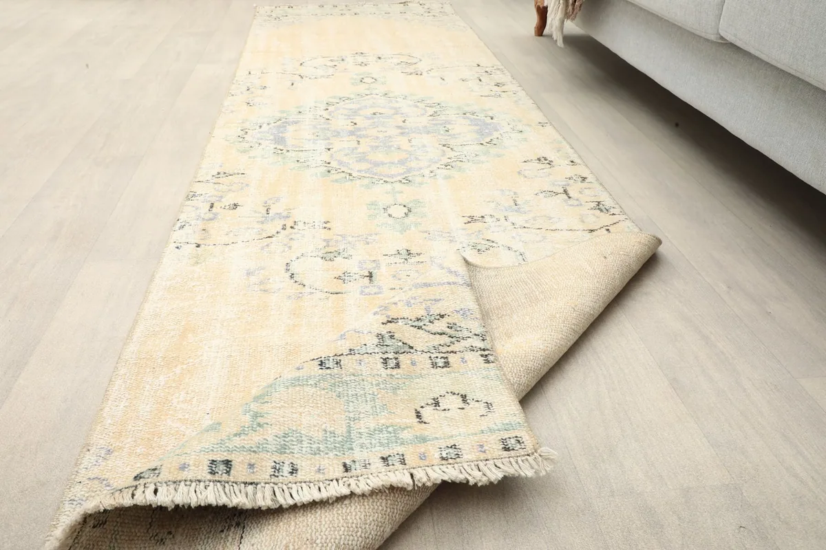 Runner rug partially unrolled, showcasing its flexibility and the underside texture.