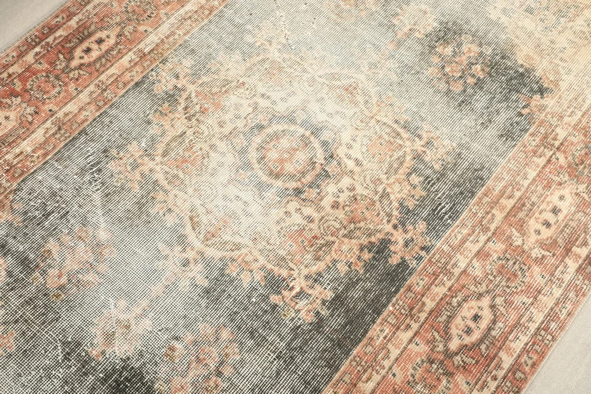 Detailed view of the central medallion design and the blend of gray, charcoal, and rust tones.