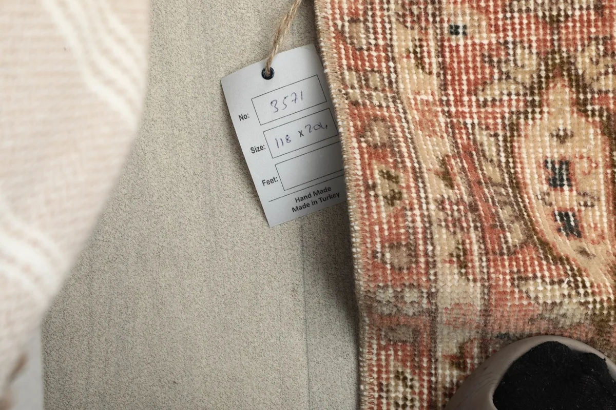 Close-up of the product tag attached to the rug, showing size and origin details.