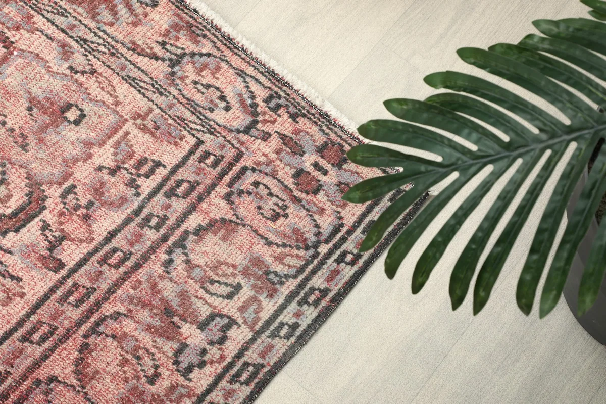 Detail of the rug's border design with floral elements and charcoal accents