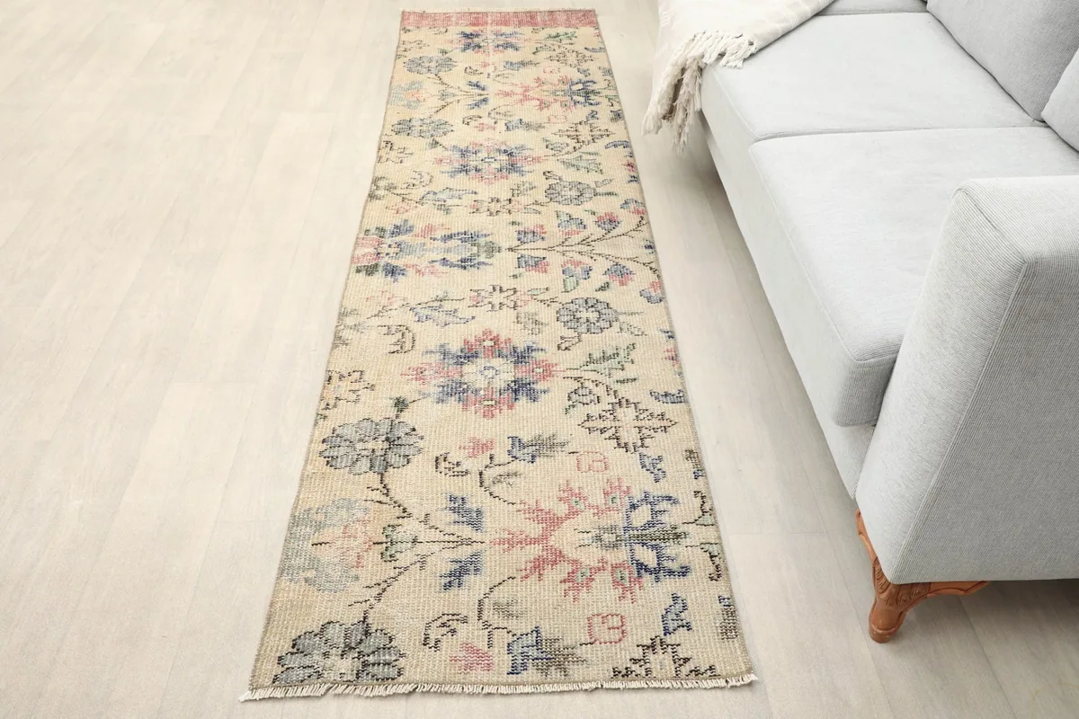 Vintage Anatolian runner placed in a room setting next to a light gray sofa