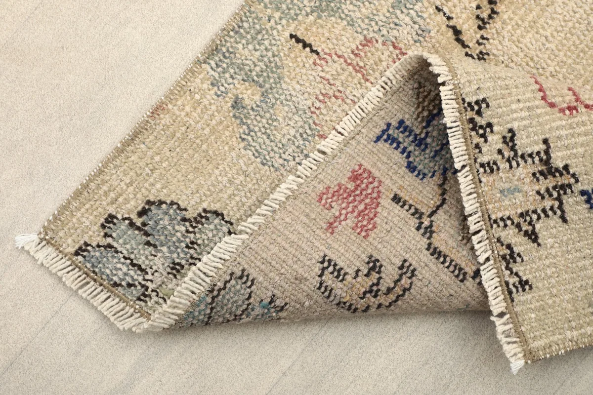Side view of the runner folded to show the thickness of the wool pile and cotton foundation