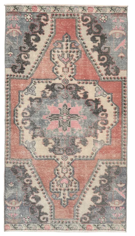 Full overhead view of a vintage rust and gray medallion rug on a white background