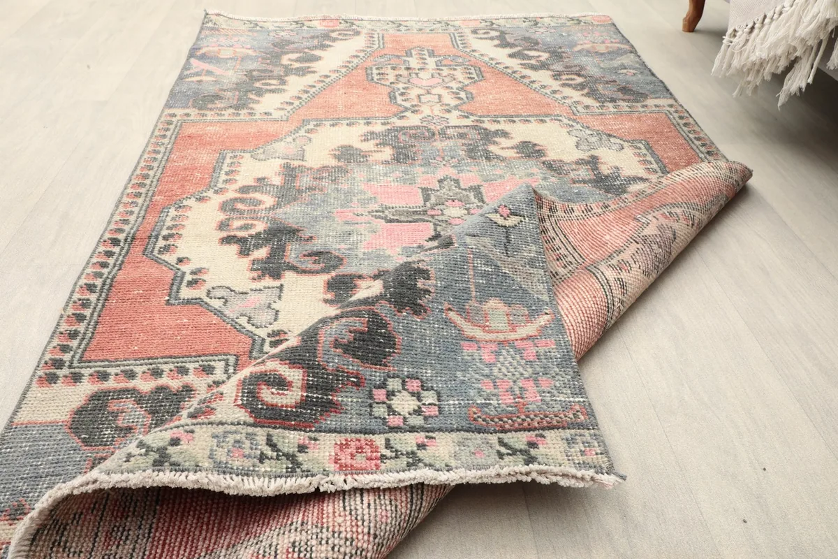 View of the rug partially rolled, showcasing the low pile and intricate weave