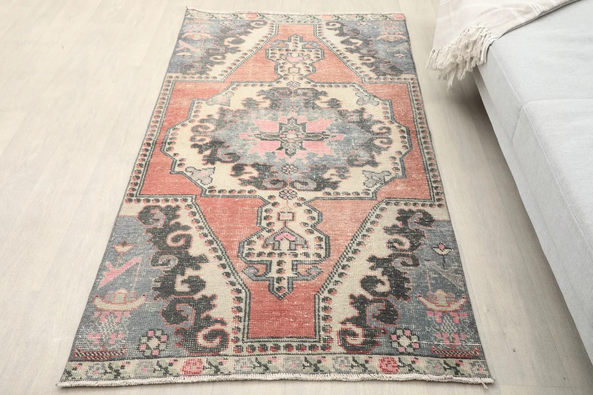 Vintage rust, gray, and beige rug with medallion pattern on a light floor
