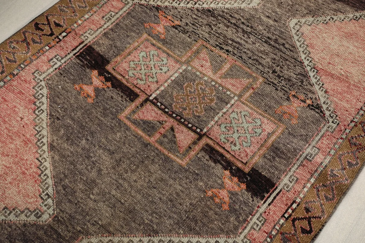 Detailed view of the intricate geometric motifs and color variations within the charcoal medallion