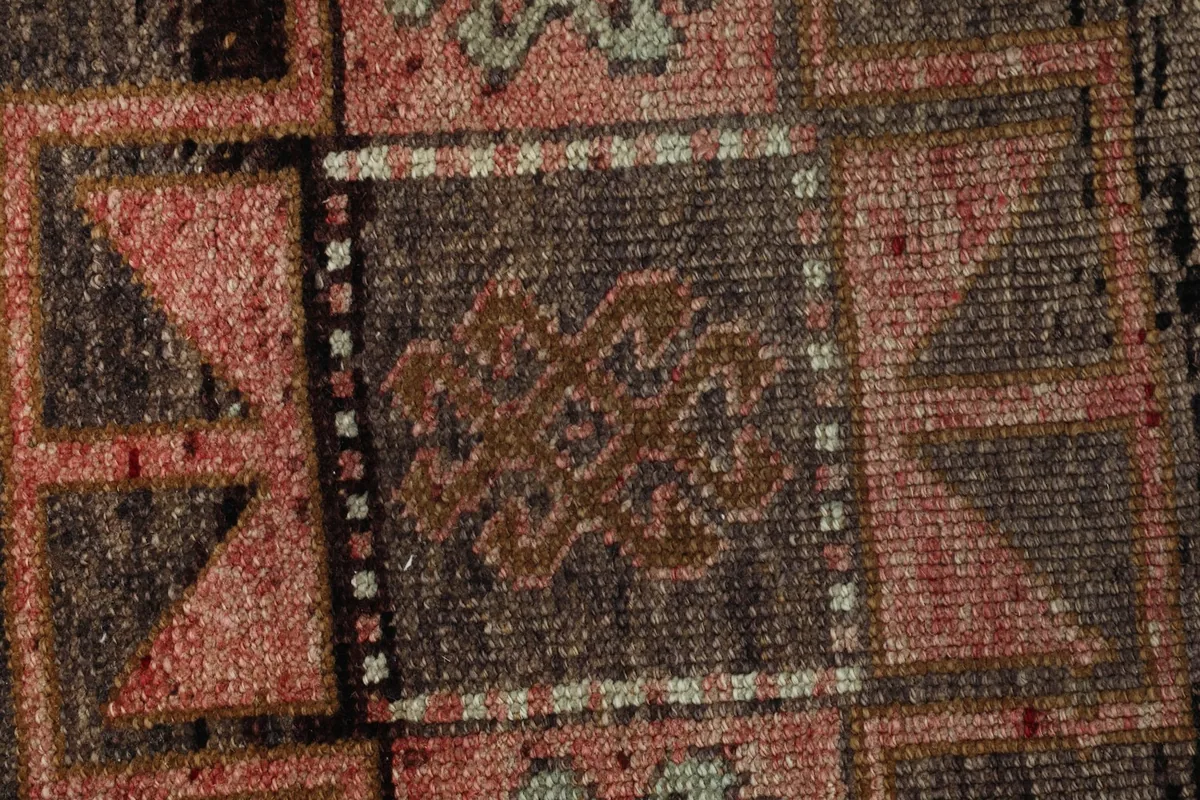 Macro shot of the hand-knotted wool pile and specific tribal motifs within the rug's design