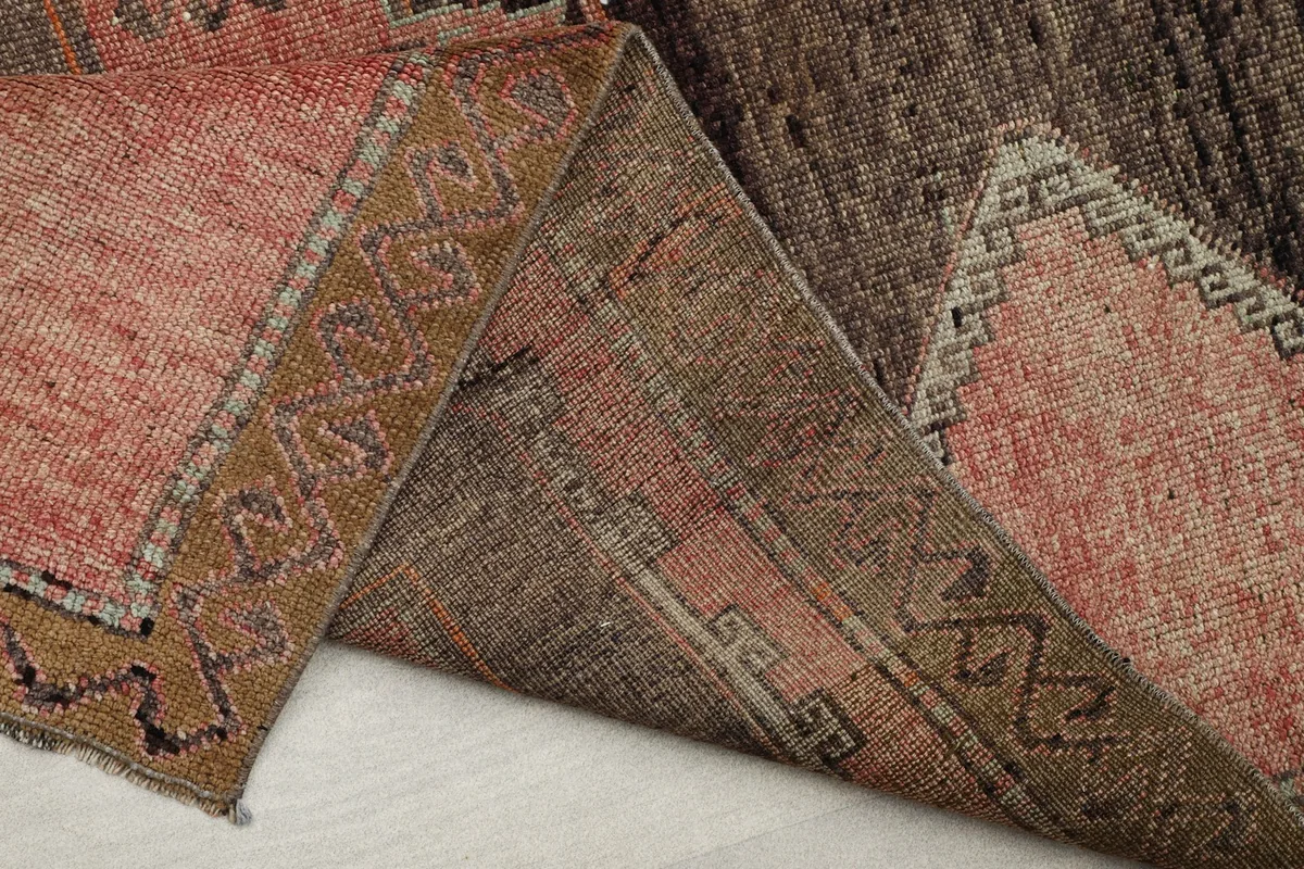 View of the back of the rug revealing the hand-knotted stitches and the cotton foundation