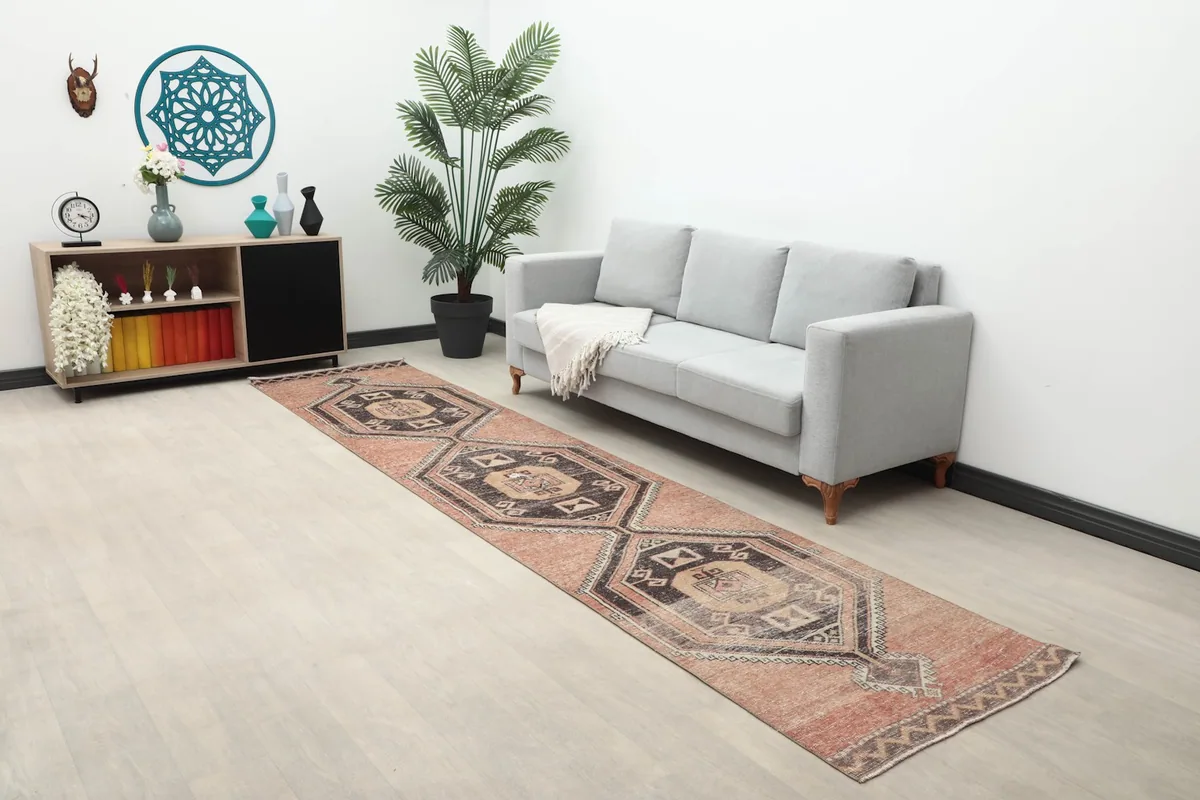 Wide view of the rust runner rug in a room setting with a sofa and decor.