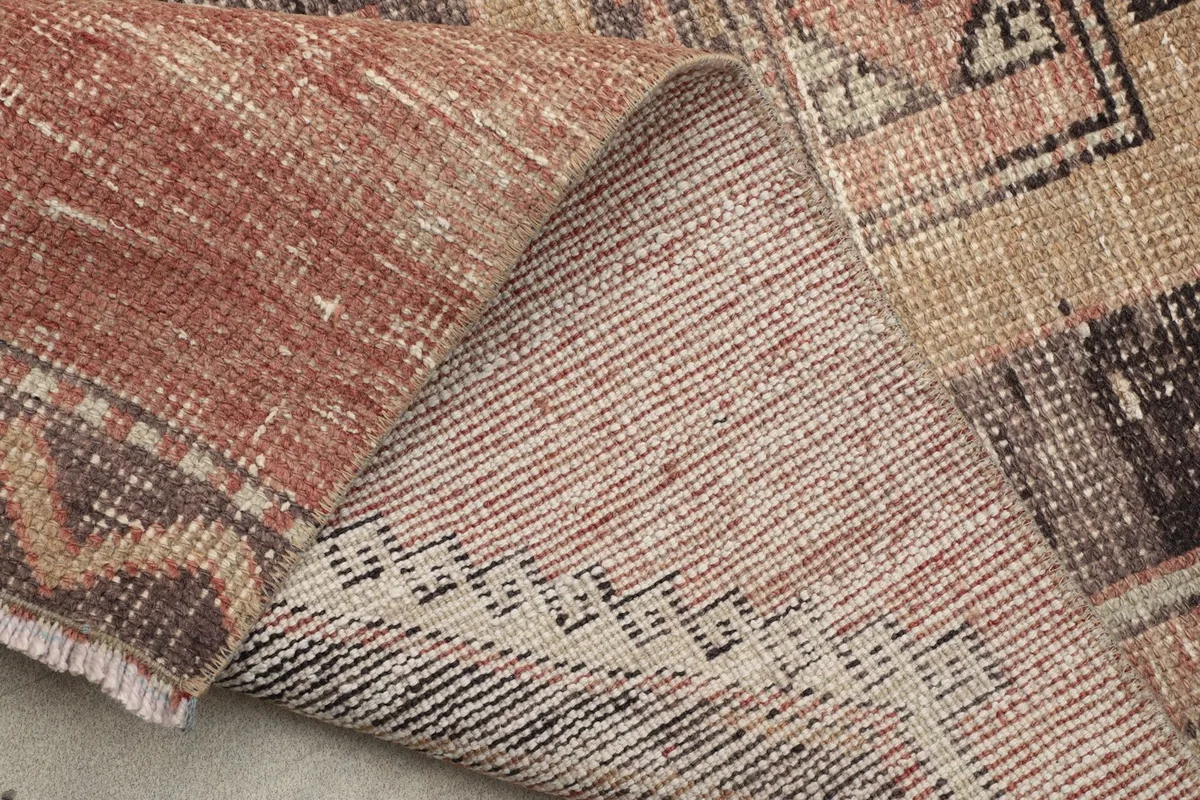 Close-up of the rug's back, displaying the tight knotting on the cotton foundation.